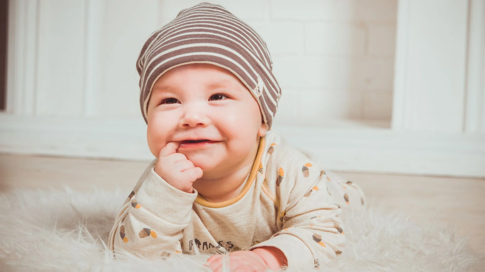 Baby chewing on a finger as a common sign of teething and increased gum discomfort.