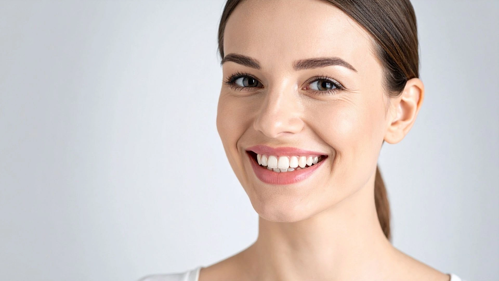 Woman smiling with straight, bright, natural-looking teeth after a smile makeover.